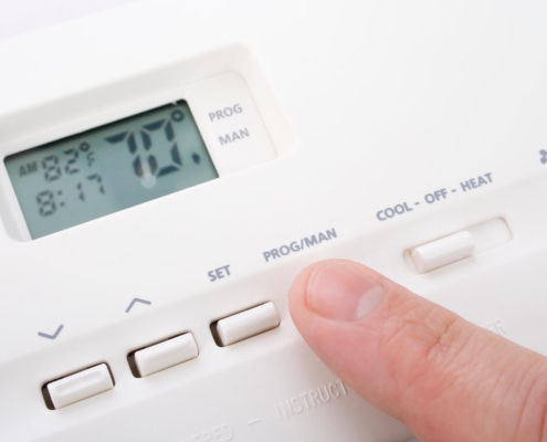 Person adjusting thermostat