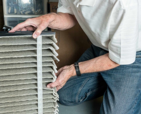 Person installing filter in furnace at home
