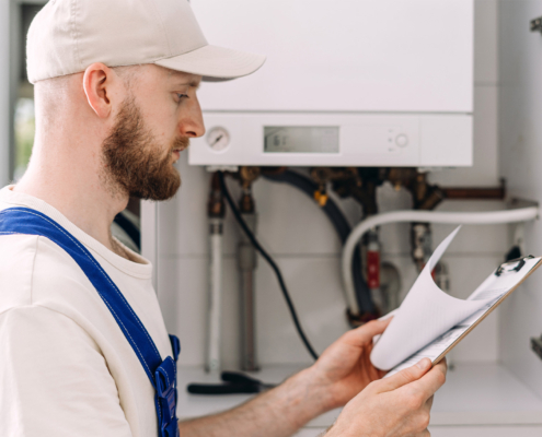 Repairman performing maintenance on gas boiler in residential bathroom